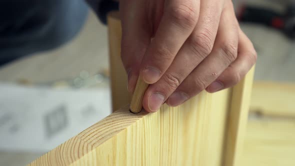 Man Assambles Furniture Screwing Boards with Bolts Closeup Hands