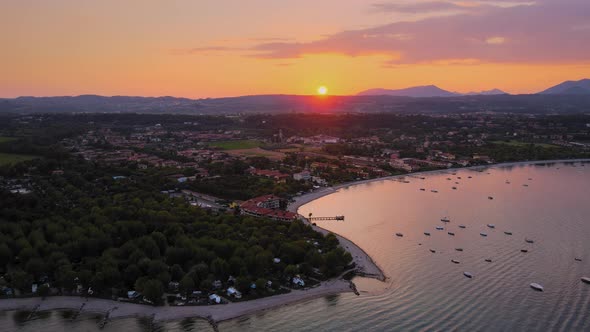 Aerial viw of a perfect idyllic sunset above Lago di Garda and Salo city, Italy.