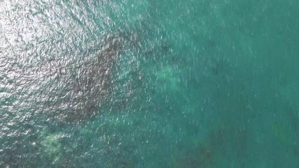 Sunlight reflecting in the small waves of the clear turquoise sea at Saint Martin Island. Drone doll