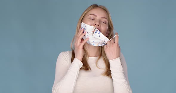 Adorable Young Girl Taking Off Her Face Mask Against Viuses with Huge Relief.