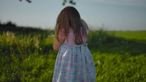 A Small Child a Girl Hugs Her Soft Toy a Hare and Goes Upset to Mom