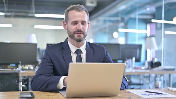 Handsome Businessman Doing Video Chat on Laptop