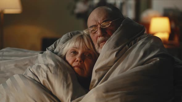 Sad Aged Couple Warming Each Other Under Blanket