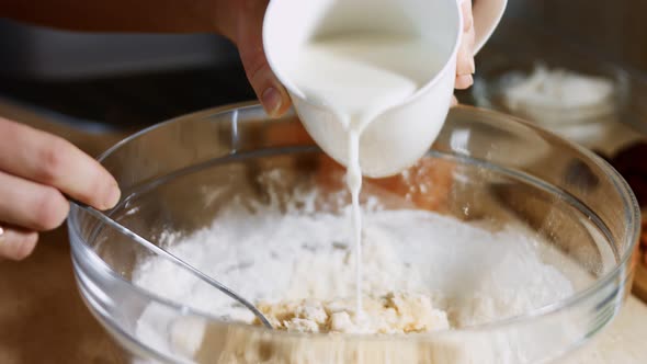 Mixing Fresh Eggs Flour and Milk with Steel Hand Mixer in a Glass Bowl