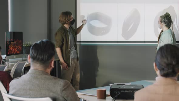 Creative Businesspeople in Face Masks Delivering Product Presentation