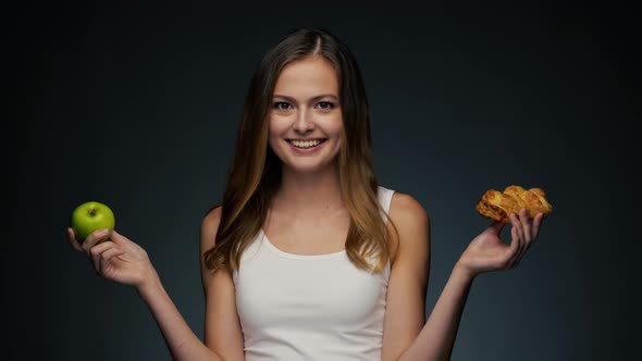 Portrait of Young Beautiful Woman. Choosing Between Healthy and Junk Food