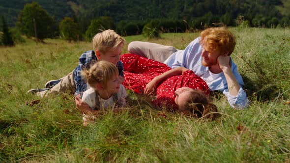 Family Lying Green Grass Beautiful Slope