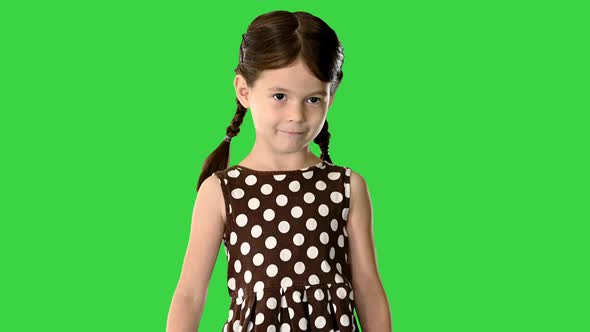 Smiling Little Girl in Polka Dot Dress with Pig Tails Walking To the Camera Looking Down at Her Feet