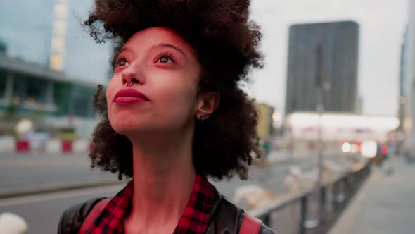 Young beautiful woman looking up smiling brightly