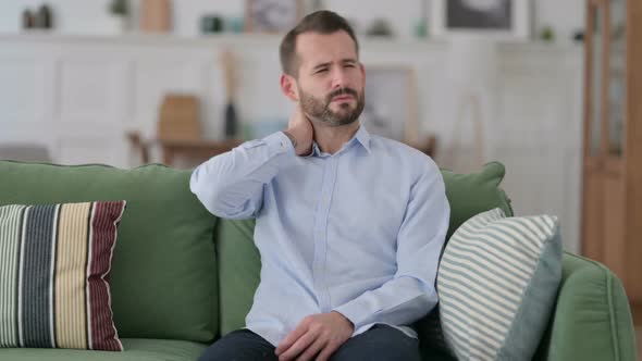 Exhausted Young Man Having Neck Pain on Sofa