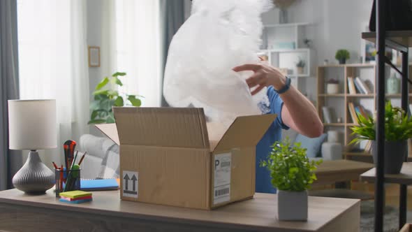 A Handsome Young Man Opens a Parcel in Which Lies the Trash