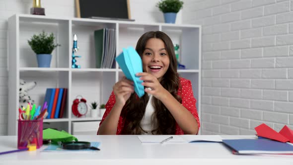 Happy Child Playing with Paper Plane While Studying School