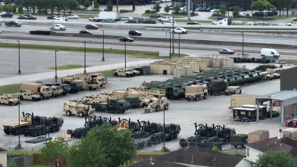 US Army Depot in USA. Camouflaged trucks and tanks ready for battle along interstate freeway highway