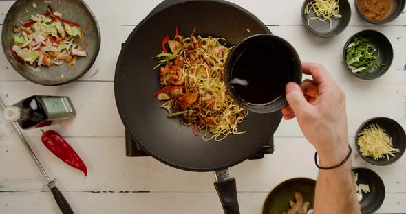 Professional Cook Frying Vegetables with Noodles