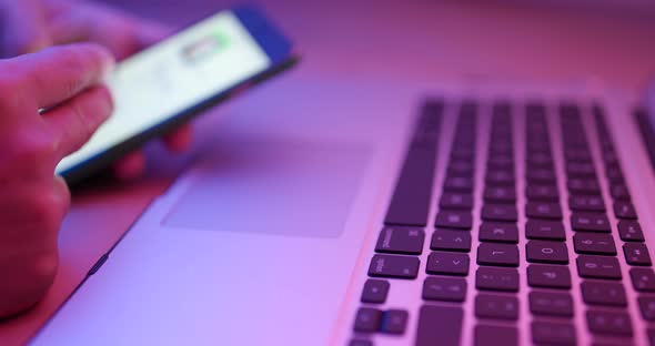 Working on Keyboard with Computer in Red and Blue Light 