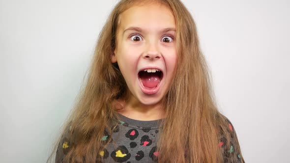  WOW Effect on Something. Pretty Teen Girl Surprised to Camera Over White Background