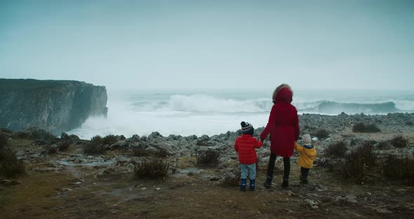 Family Came to Watch Big Storm Waves at the Edge of Ocean Shore