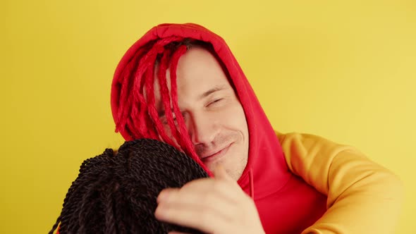 Young Man in Hood Hugging Unrecognizable Woman and Stroking Her Head