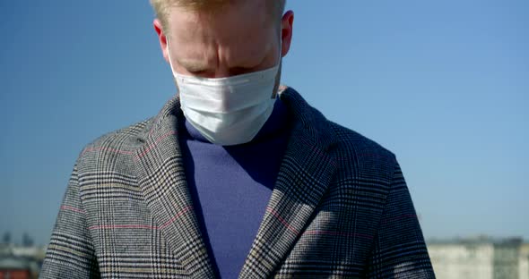 Young Man with Surgical Mask on Face for Protection From Influenza and Coronavirus at Street