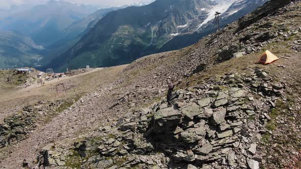 Woman Stands on Stone and Enjoys View of Elbrus Mountains
