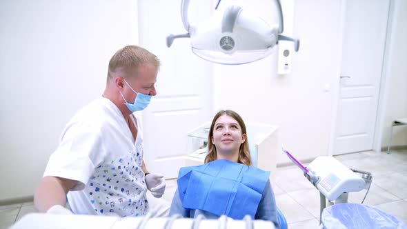 Woman having visit at the dentist. Dentist curing a female patient in the stomatology