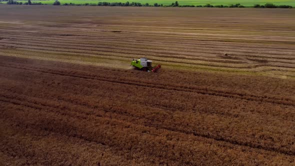 Aerial view large tractor cultivating a dry field. Top down aerial view tractor cultivating ground