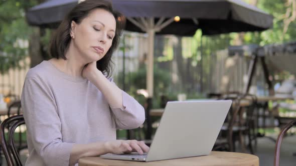 Old Woman with Neck Pain Using Laptop Outdoor