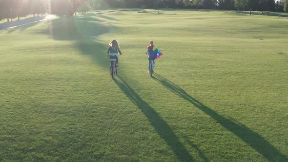 Aerial Shot of Gay Couple Riding Bikes Across Lawn