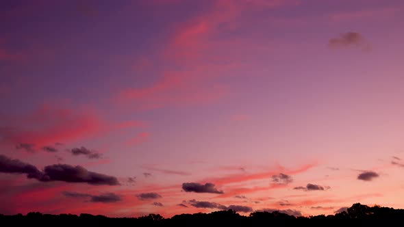 slowing dark clouds in a pink and purple dusk sunset sky 4k