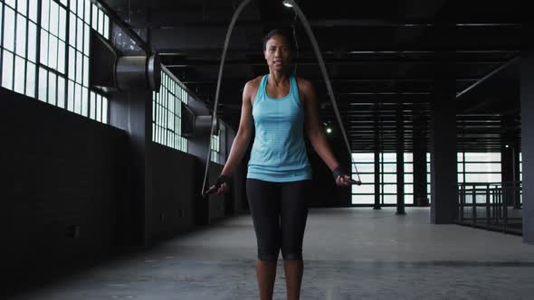 African american woman skipping the rope in an empty urban building