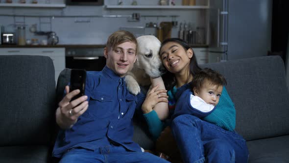 Smiling Family with Dog Taking Sefie on Cellphone