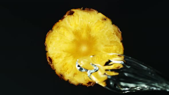 Super Slow Motion Shot of Splashing Water on Rotating Pineapple Slice at 1000Fps.