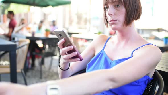 young beautiful woman outdoor sitting bar using smart phone