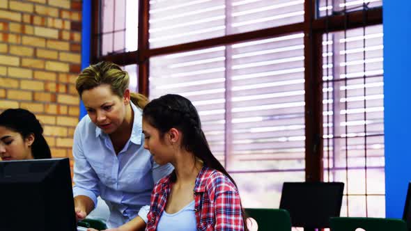 Teacher assisting students in computer class