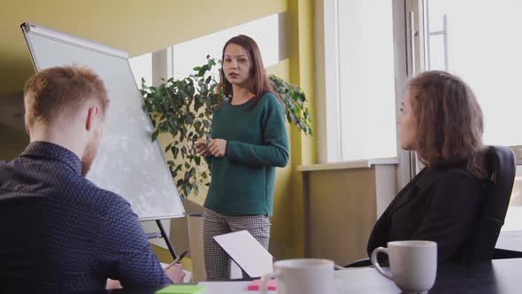 Young Business People Discussing Company Financial Report on White Board in Office. Business