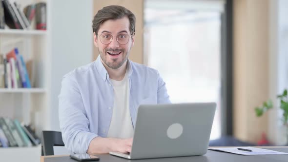 Man in Glasses with Laptop Feeling Surprised