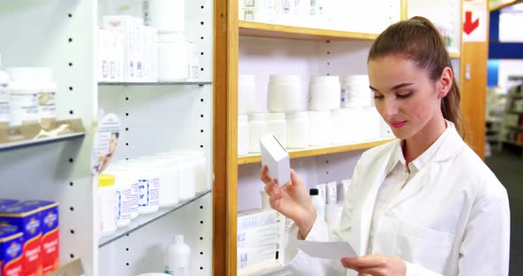 Pharmacist checking at prescription and medicine box