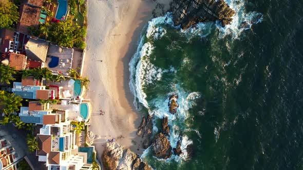 top down view of beautiful white sand rocky beach at Playa Amapas in Puerto Vallarta Mexico at sunse