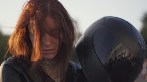 Beautiful Young Redhaired Woman Motorcyclist with Black Motorcycle Helmet