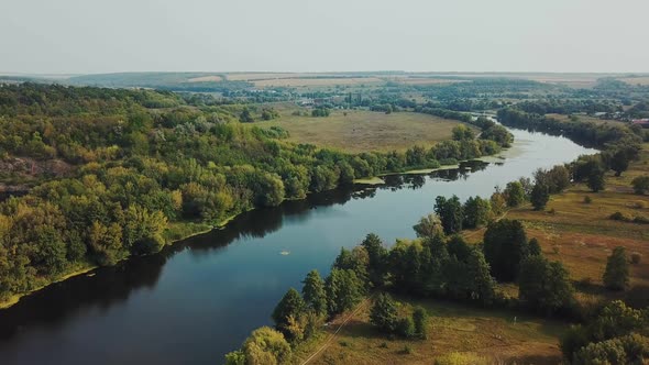 Aerial View. Flying over the beautiful sunny forest trees. Landscape panorama.