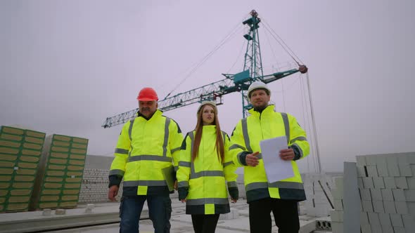 Professional Team of Civil Engineers in Construction Site Two Foreman and Female Architect alt