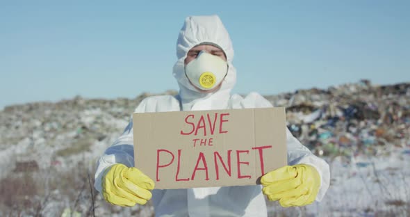 Portrait of Man Wore in Protective Suit Shows Protest Sign "Save the Planet"