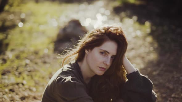 Slow motion shot of redheaded woman looking at camera