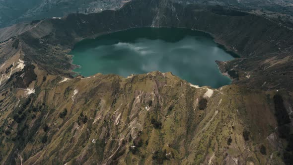 Aerial tilt up shot of Quilotoa Crater Lake inside Volcano during cloudy day in Andes,Ecuador