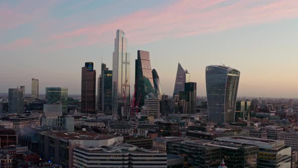 Slow dolly forward aerial drone shot of City of London skyscraper buildings beautiful sunrise