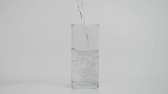 1000 Fps Shot of Pouring Water in Transparent Glass White Background