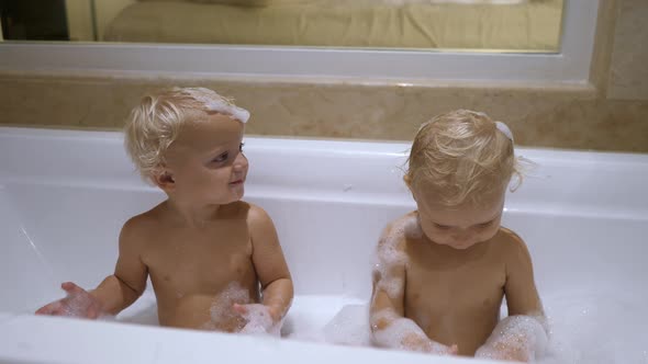 Two Caucasian Twins Washing Them Self with Soap Foam in the Bath