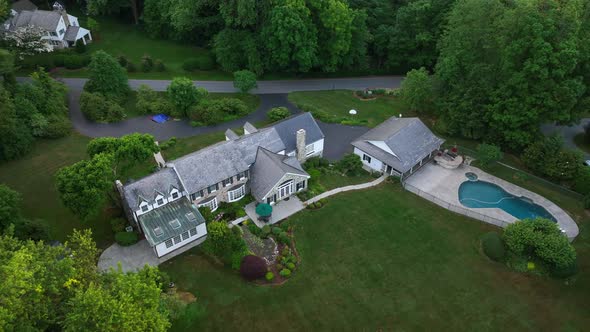 Establishing shot of a countryside estate. Mansion on large plot of green land near a countryclub. S