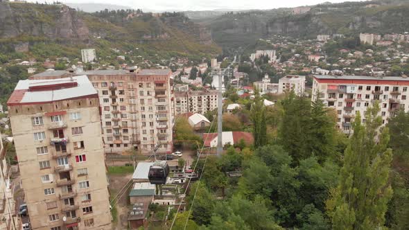 Cable Car Passing By Old Soviet Era Buildings in Chiatura Miners City in Georgia
