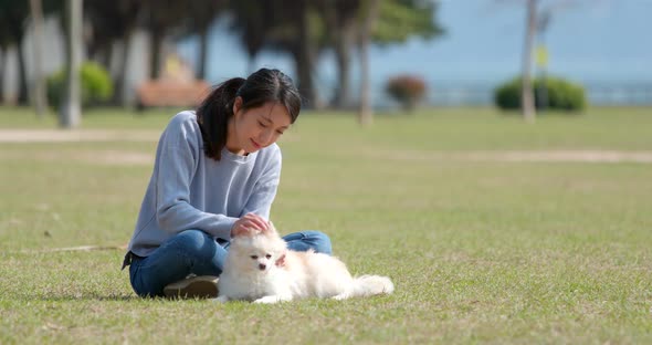 Asian Woman playing with her dog at outdoor park